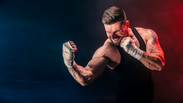 Sportivo muay thai boxer combattendo su sfondo nero con fumo.