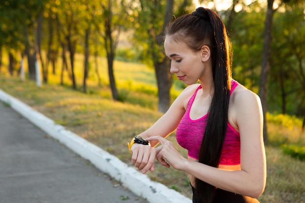 Sportwoman che controlla il dispositivo indossabile di monitoraggio della forma fisica e della salute