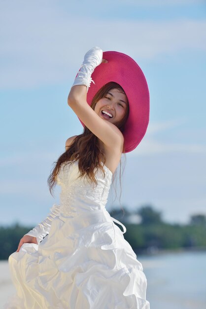 sposa asiatica con un velo sulla spiaggia nel cielo e mare blu. luna di miele sulla fantastica isola in estate