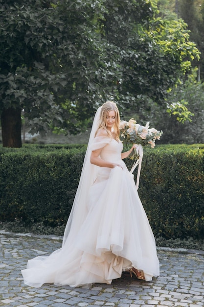 sposa attraente in abito tradizionale con bouquet da sposa