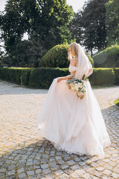 sposa attraente in abito tradizionale con bouquet da sposa