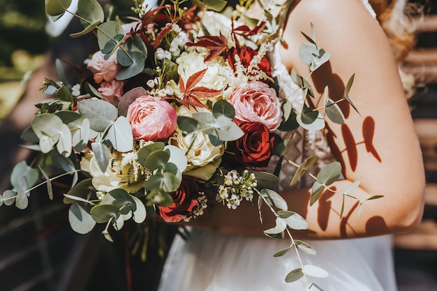 Sposa azienda bouquet da sposa con fiori rossi e rosa