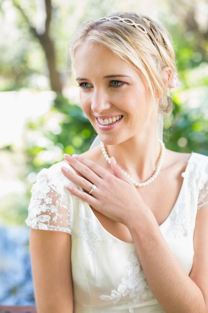 Sposa bionda felice con la mano sul petto