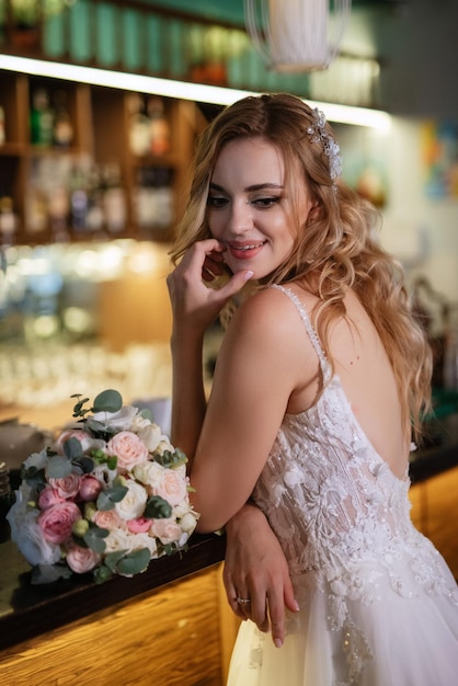 Sposa bionda in un bar vicino con un bouquet da sposa