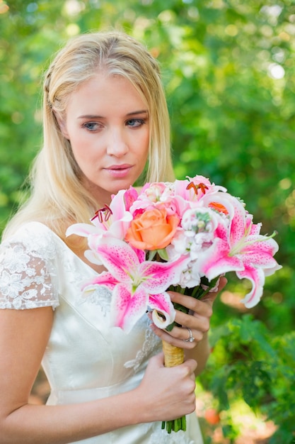 Sposa calma che tiene il suo mazzo