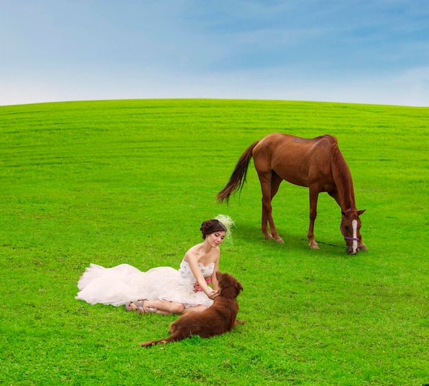 Sposa che gioca con l'animale sul campo verde
