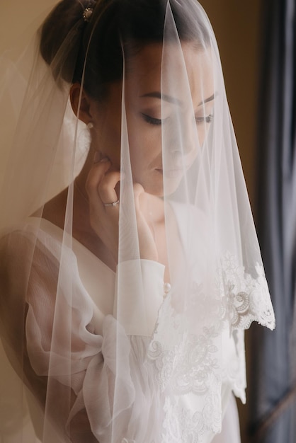 Sposa che guarda fuori dalla finestra al suo matrimonio