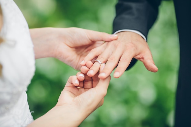 Sposa che mette un anello al dito dello sposo