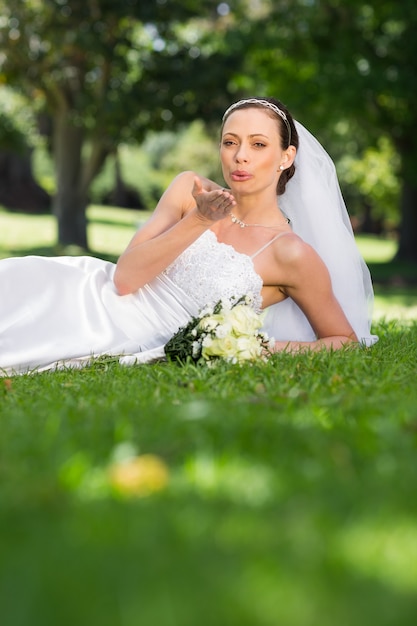 Sposa che soffia un bacio nel parco