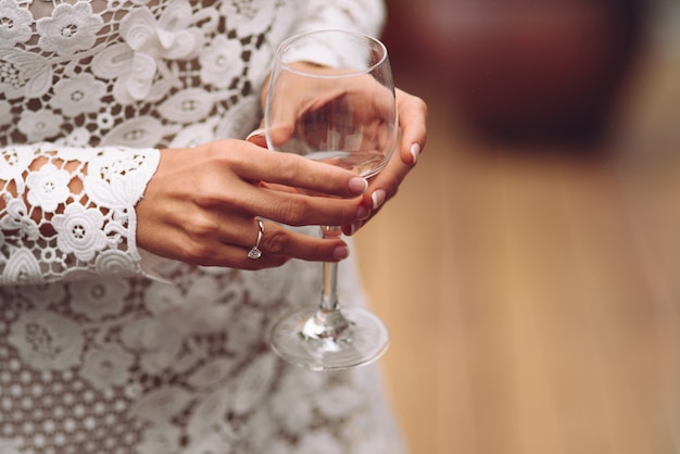 Sposa che tiene un bicchiere di champagne. Feste di matrimonio, cena di nozze