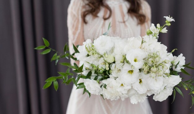 Sposa con bouquet da sposa bianco