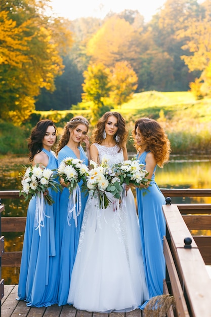 Sposa con le damigelle nel parco il giorno del matrimonio