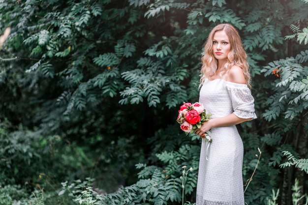 Sposa con un bouquet di peonie tra le mani