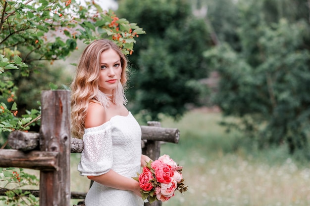 Sposa con un bouquet di peonie tra le mani