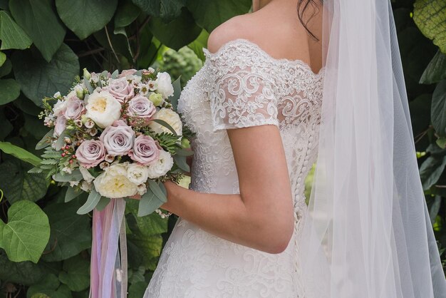 Sposa con un mazzo di fiori nel parco