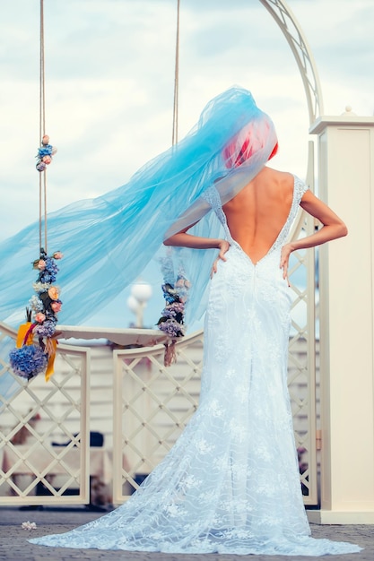 Sposa con velo blu vicino all'altalena