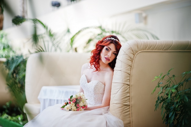 Sposa dai capelli rossi affascinante con il mazzo di nozze