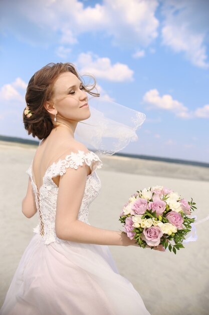 Sposa della donna in vestito da sposa nel dancing del deserto