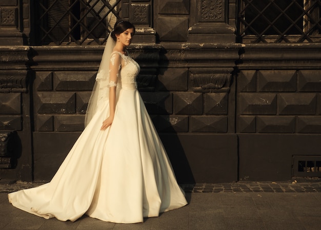 Sposa di bellezza donna in abito da sposa bianco incredibile e tramonto in città