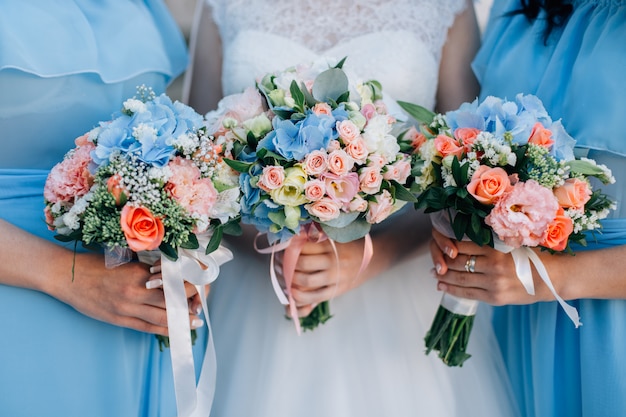 Sposa e damigelle che tengono bellissimi fiori