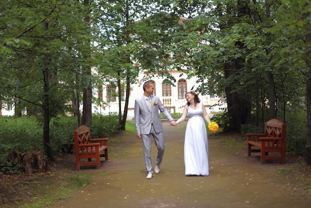 sposa e sposo a piedi nel parco in estate