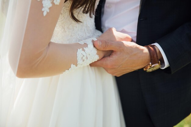 Sposa e sposo al giorno delle nozze che camminano all'aperto sulla natura verde d'estate.