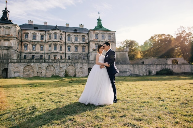 Sposa e sposo al giorno delle nozze che si abbracciano e si baciano con lovex9