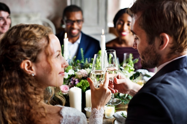 Sposa e sposo brindando con bicchieri di vino a un ricevimento di nozze