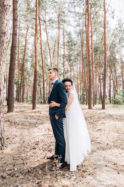 Sposa e sposo che abbracciano, baciano all'aperto in un giorno di nozze, giovane coppia, San Valentino