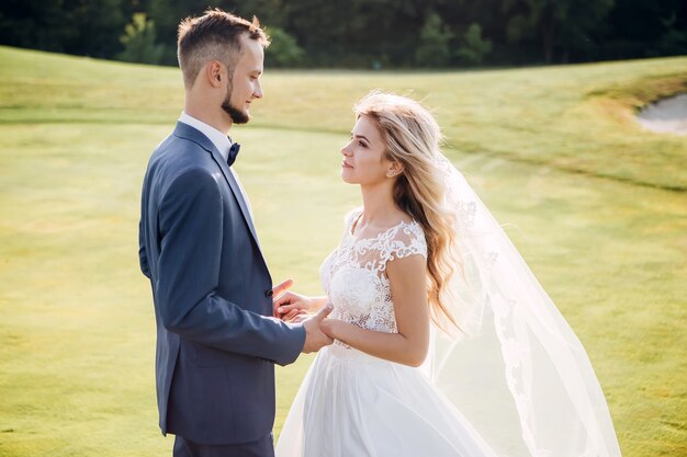 Sposa e sposo che abbracciano, baciano all'aperto in un giorno di nozze, giovane coppia, San Valentino