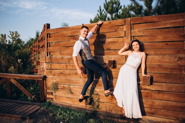 Sposa e sposo che abbracciano, baciano all'aperto in un giorno di nozze, giovane coppia, San Valentino