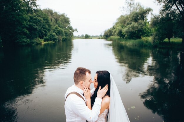 Sposa e sposo che abbracciano il giorno del matrimonio, giovani coppie felici che baciano nel parco in natura, San Valentino