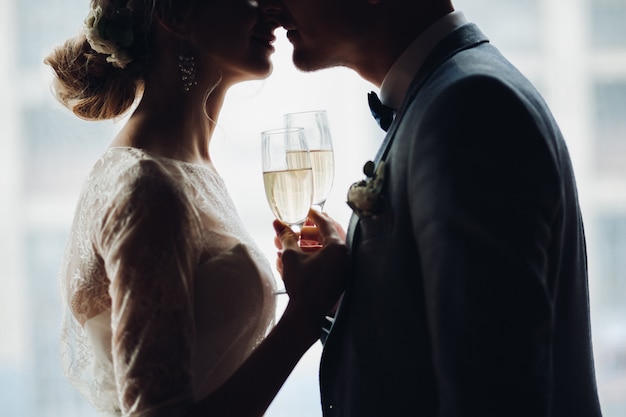 Sposa e sposo che si abbracciano e che si tengono per mano