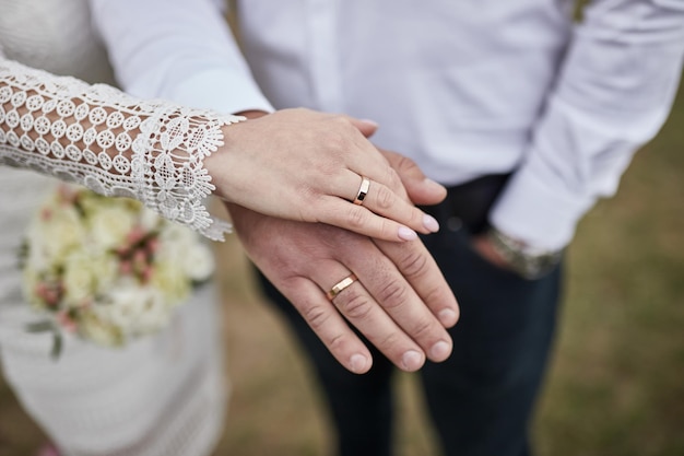 Sposa e sposo che si tengono per mano all'aperto a tema di nozze