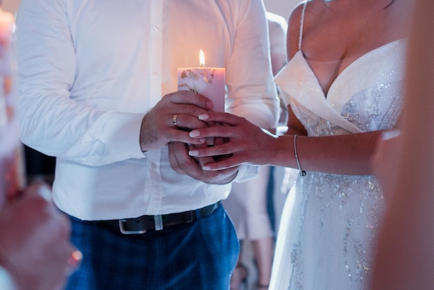 Sposa e sposo che tengono una candela al matrimonio