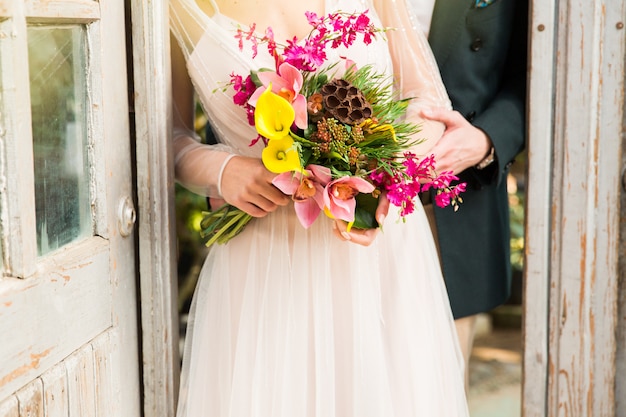 Sposa e sposo con bouquet da sposa di fiori