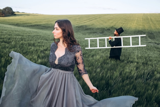 Sposa e sposo eleganti che camminano e che posano sul campo verde