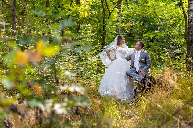 Sposa e sposo eleganti che posano insieme all'aperto il giorno del matrimonio