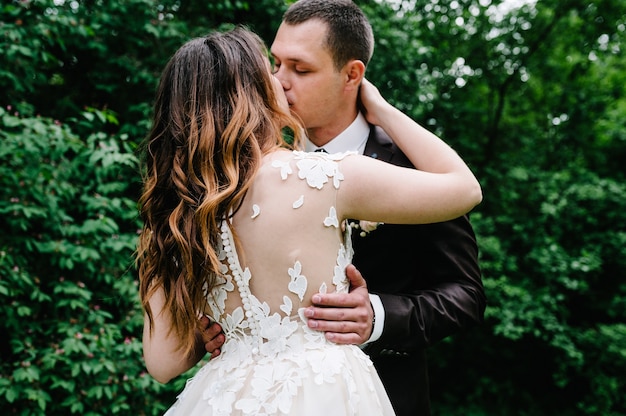 Sposa e sposo felici che si sposano nella foresta verde.