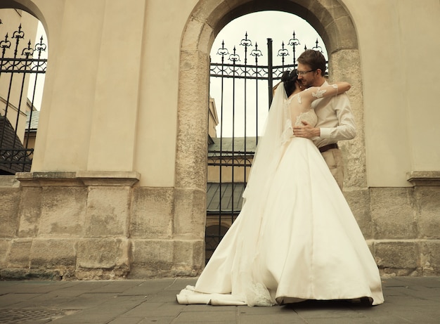 Sposa e sposo felici romantici di lusso che celebrano il matrimonio sullo sfondo della vecchia città soleggiata