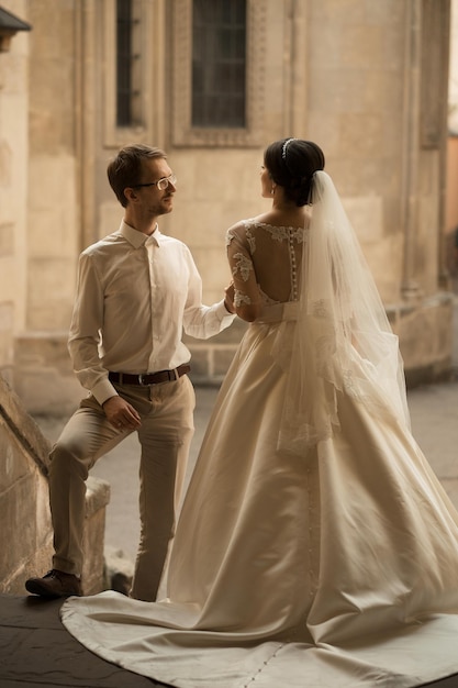 Sposa e sposo felici romantici di lusso che celebrano il matrimonio sullo sfondo della vecchia città soleggiata