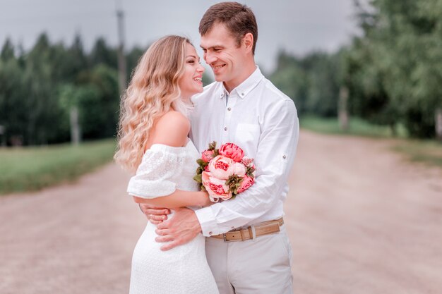 Sposa e sposo in posa su una strada