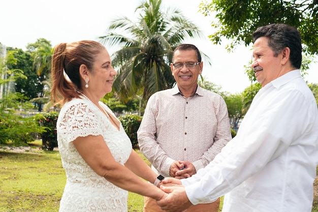 Sposa e sposo maturi che si tengono per mano ad un matrimonio