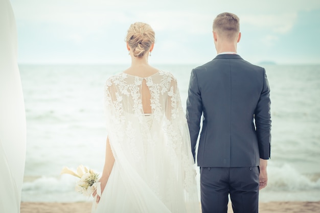 Sposa e sposo sulla spiaggia con un momento romantico