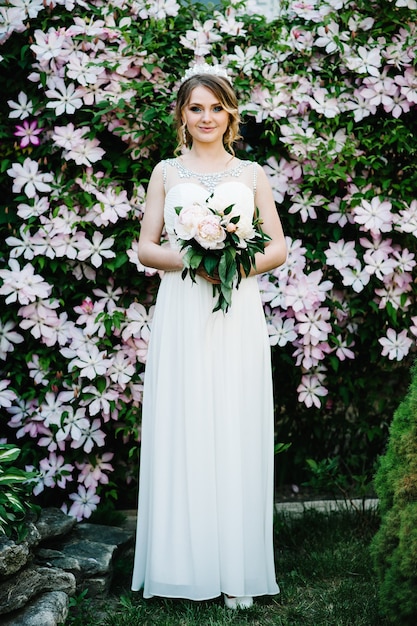 Sposa elegante ritratto con bouquet di peonie con corona