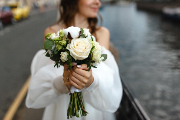 sposa gentile con un bouquet di fiori bianchi nelle sue mani