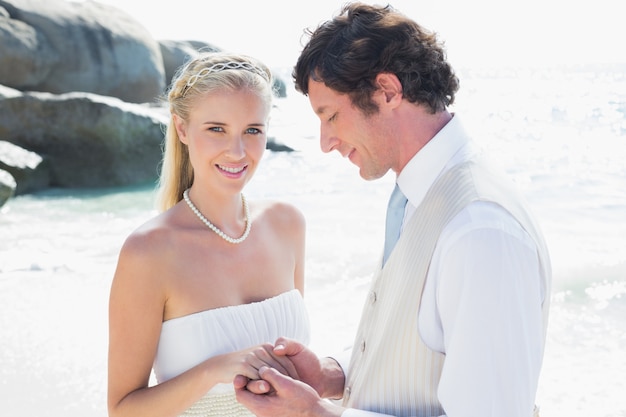 Sposa graziosa che sorride alla macchina fotografica con il marito