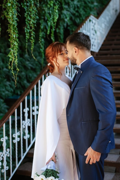 Sposa in abito bianco con bouquet e sposo in abito blu