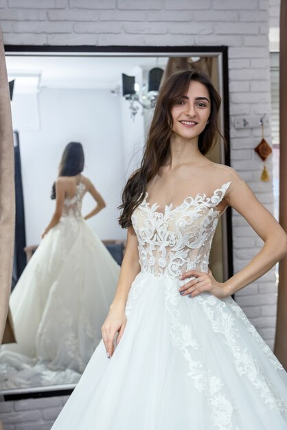 Sposa in abito da sposa in posa con le mani sulla vita