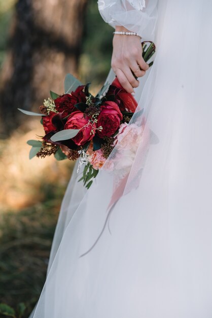 Sposa in un abito da sposa bianco con un bouquet